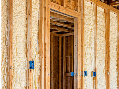 Spray foam insulation installed between wooden wall studs in new construction