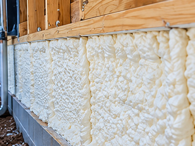 Spray foam insulation installed along the lower exterior wall of a residential building