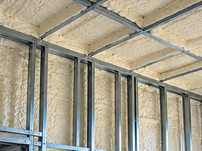 Spray foam insulation applied between metal wall studs in a commercial building