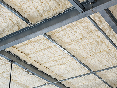 Spray foam insulation installed along a commercial metal roof assembly